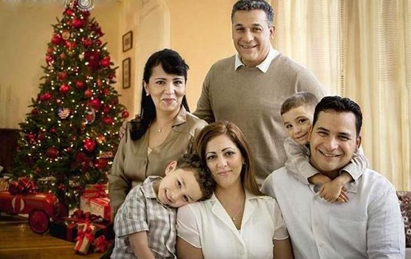 hispanic_family_smiling_in_living_room_at_christmas_time_BLD073802